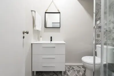 a white bathroom with a toilet and a mirror at Sta Catarina - 2 Bedroom Apartament in Porto