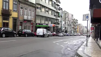 a busy city street with cars parked on the street at Camões Loft in Porto