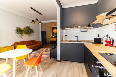 a kitchen and living room with a table and chairs at Camões Loft in Porto