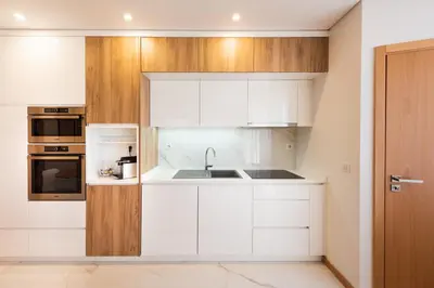 a kitchen with white cabinets and a sink at Casa das Musas 2 in Porto