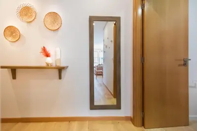 a mirror on a wall next to a hallway at Casa das Musas 2 in Porto