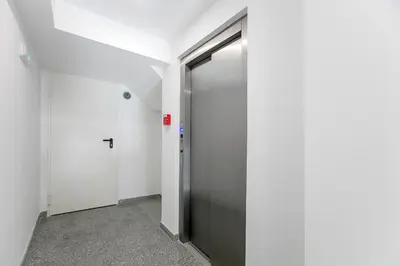 a hallway with a metal door in a building at Newly Renovated Cozy Central Loft w/ AC by LovelyStay in Porto