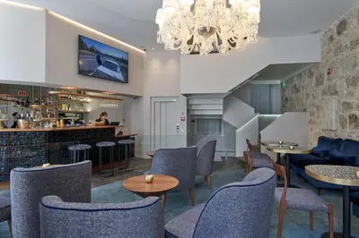 a restaurant with chairs and tables and a bar at Rio da Vila in Porto