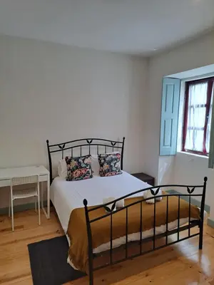 a bedroom with a bed with white sheets and a window at Near River 63 in Vila Nova de Gaia