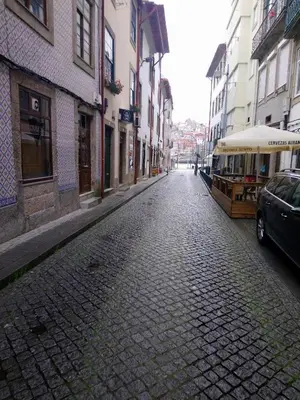 a cobblestone street with a trolley car on a city street at Near River 63 in Vila Nova de Gaia