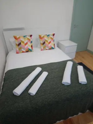 a bed with two pillows and two slippers on it at Near River 63 in Vila Nova de Gaia