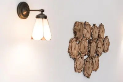 a wall mounted light with a bunch of wood pieces at GuestReady - Nature-themed Studio in Porto