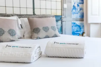 a bed with two pillows and two towels on it at GuestReady - Nature-themed Studio in Porto