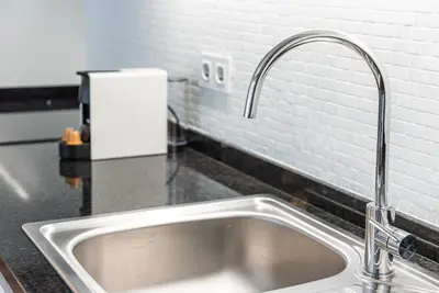 a kitchen sink with a faucet on a counter at GuestReady - Nature-themed Studio in Porto