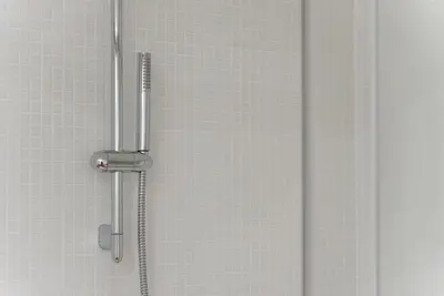 a shower in a bathroom with white tiles at GuestReady - Nature-themed Studio in Porto