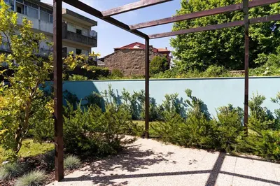 a garden with a pergola next to a fence at Casa Nina in Porto
