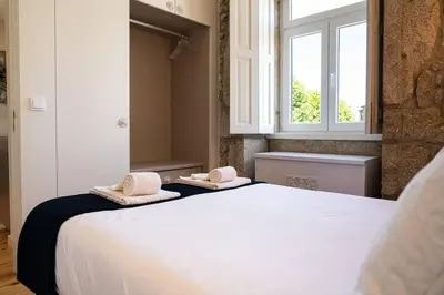a bedroom with a bed with two towels on it at Casa Nina in Porto