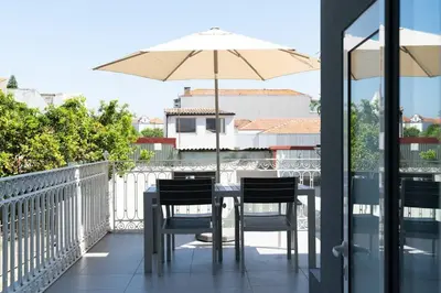 a table with chairs and an umbrella on a balcony at Joy Porto in Porto