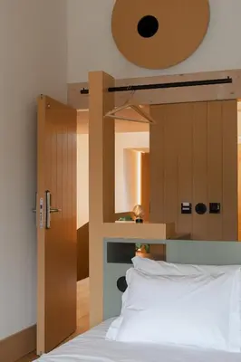 a bedroom with a bed with a wooden headboard at Na Travessa Suítes in Porto