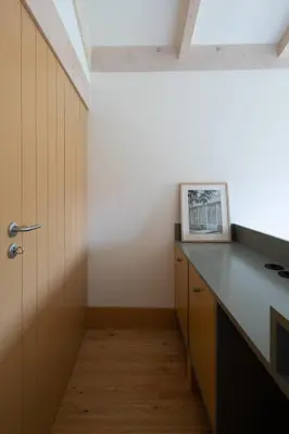 a kitchen with a counter and a door at Na Travessa Suítes in Porto