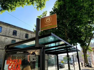 a bus stop with a sign on top of it at Miragaia Rio in Porto