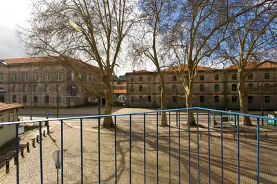 a fence in front of a building with trees at Miragaia Rio in Porto