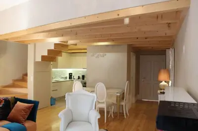 a living room with a table and chairs and a kitchen at GuestReady - Beige Glamour in Porto