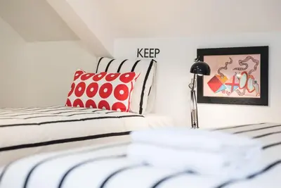 a bedroom with a bed with red and white pillows at GuestReady - Belas Artes Duplex in Porto