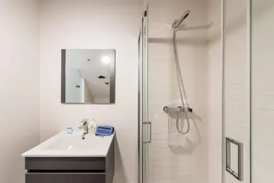 a white bathroom with a sink and a shower at GuestReady - Belas Artes Duplex in Porto