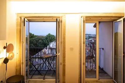 a room with a balcony with a view of a table at Lemago Porto Apartments - Poveiros in Porto