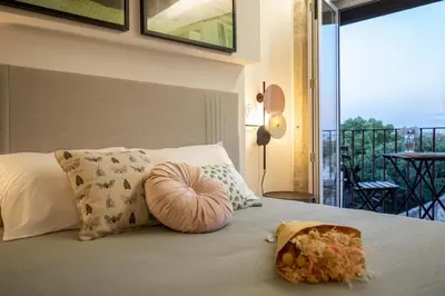 a bed with pillows and a bag of food on it at Lemago Porto Apartments - Poveiros in Porto
