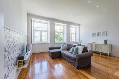 a living room with a couch and a tv at GuestReady - Cityscape coastal flat in Porto
