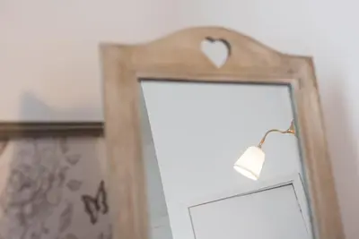 a mirror with a wooden frame with a heart above it at GuestReady - Cityscape coastal flat in Porto