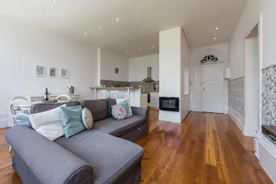 a living room with a couch and a kitchen at GuestReady - Cityscape coastal flat in Porto