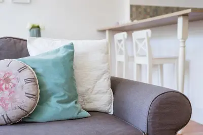 a couch with two pillows on top of it at GuestReady - Cityscape coastal flat in Porto