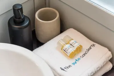 a bathroom sink with a towel and a bottle of soap at GuestReady - Bourse Apartments in Porto