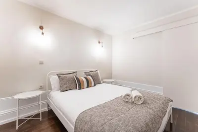 a white bedroom with a bed with two towels on it at GuestReady - Bourse Apartments in Porto