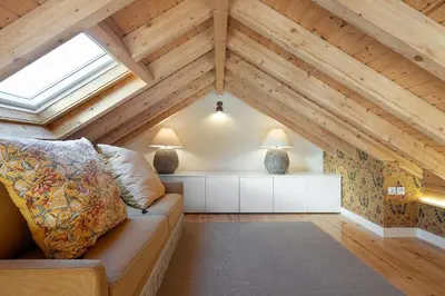 a attic room with a couch and two lamps at Líbere Porto Laranjais in Porto
