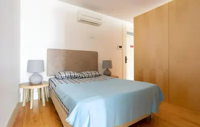 a bedroom with a bed with a blue comforter at Oporto Blue Almada - Deluxe Citycenter Flat in Porto