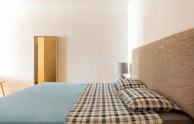 a bedroom with a bed with a headboard and two pillows at Oporto Blue Almada - Deluxe Citycenter Flat in Porto