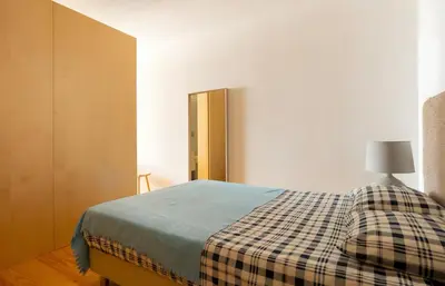 a bedroom with a bed with a plaid blanket at Oporto Blue Almada - Deluxe Citycenter Flat in Porto
