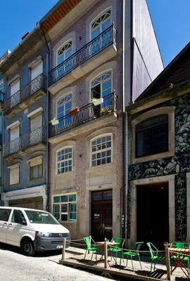 a building with green chairs in front of it at Oporto Blue Almada - Deluxe Citycenter Flat in Porto
