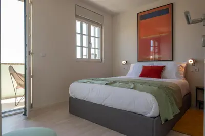 a bedroom with a large bed with a red pillow at The Cathedral's Terrace in Porto