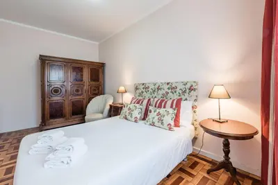 a bedroom with a white bed and a table and a chair at GuestReady - Urban escape in Porto in Porto