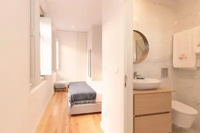 a white bathroom with a sink and a toilet at HM – Oporto Downtown Swimming Pool Apartment in Porto