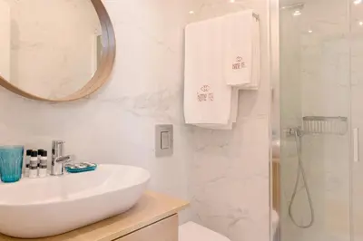 a white bathroom with a sink and a shower at HM – Oporto Downtown Swimming Pool Apartment in Porto