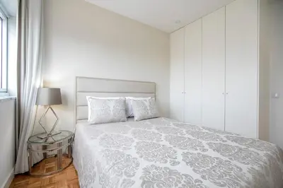 a white bedroom with a bed and a table at Casa D'Ouro Apartment by Oporto Soul in Porto