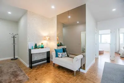 a living room with a white chair and a mirror at Casa D'Ouro Apartment by Oporto Soul in Porto