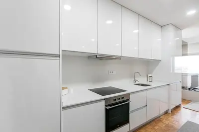 a white kitchen with white cabinets and a sink at Casa D'Ouro Apartment by Oporto Soul in Porto