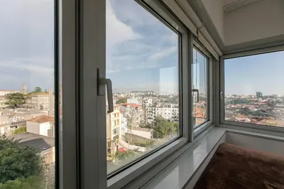 a room with windows looking out at a city at Casa D'Ouro Apartment by Oporto Soul in Porto