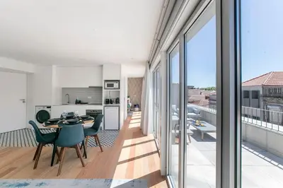 a kitchen and dining room with a table and chairs at Luminous Premium Loft w/AC & Terrace by LovelyStay in Porto