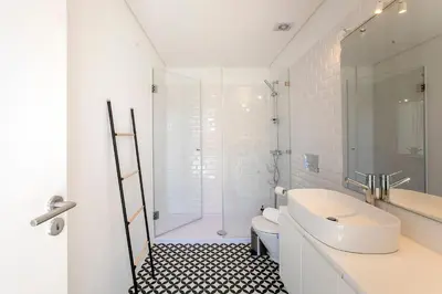 a white bathroom with a sink and a shower at Luminous Premium Loft w/AC & Terrace by LovelyStay in Porto