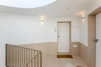a hallway with a staircase and a white wall at Luminous Premium Loft w/AC & Terrace by LovelyStay in Porto