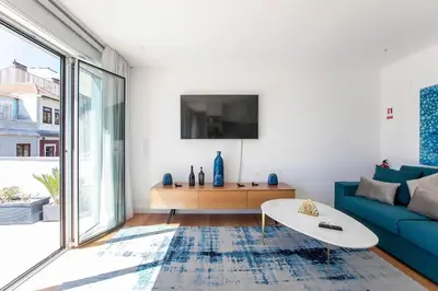a living room with a blue couch and a table at Luminous Premium Loft w/AC & Terrace by LovelyStay in Porto