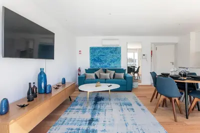 a living room with a blue couch and a table at Luminous Premium Loft w/AC & Terrace by LovelyStay in Porto